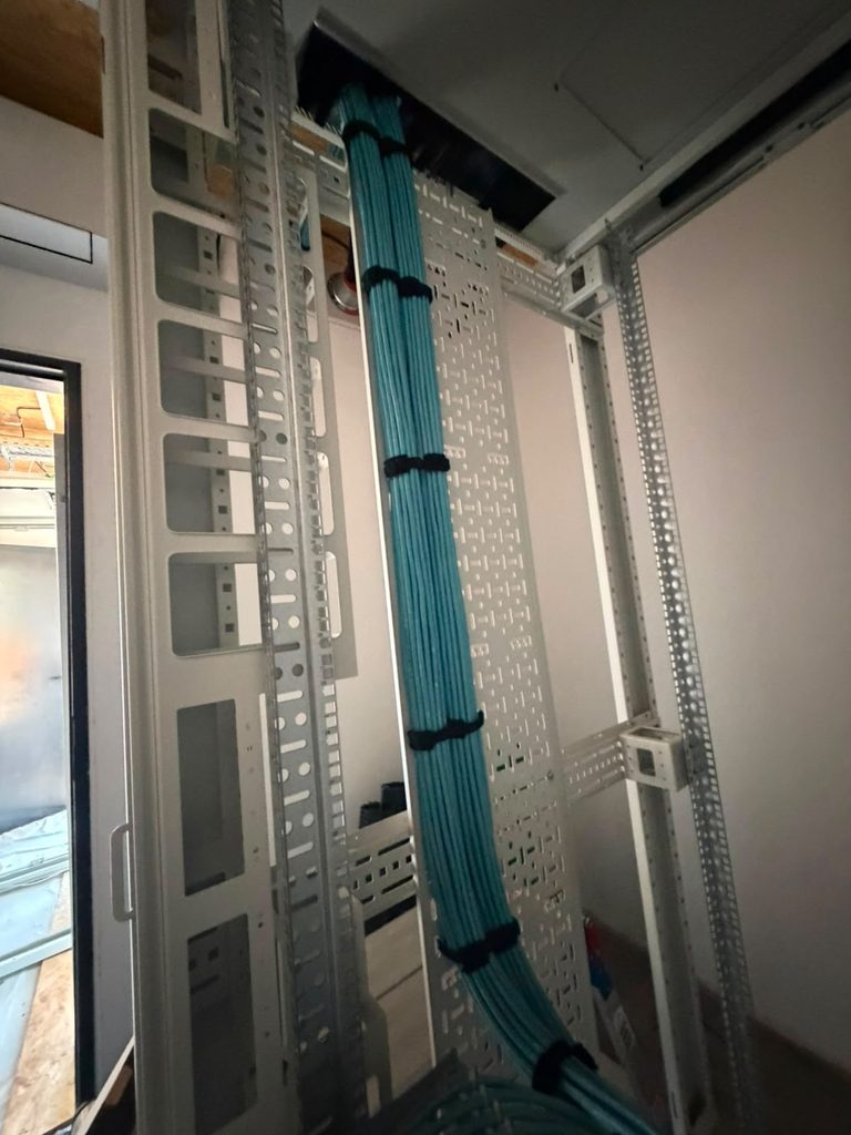Cat6a loom dressed down the cabinet frame on vertical cable management