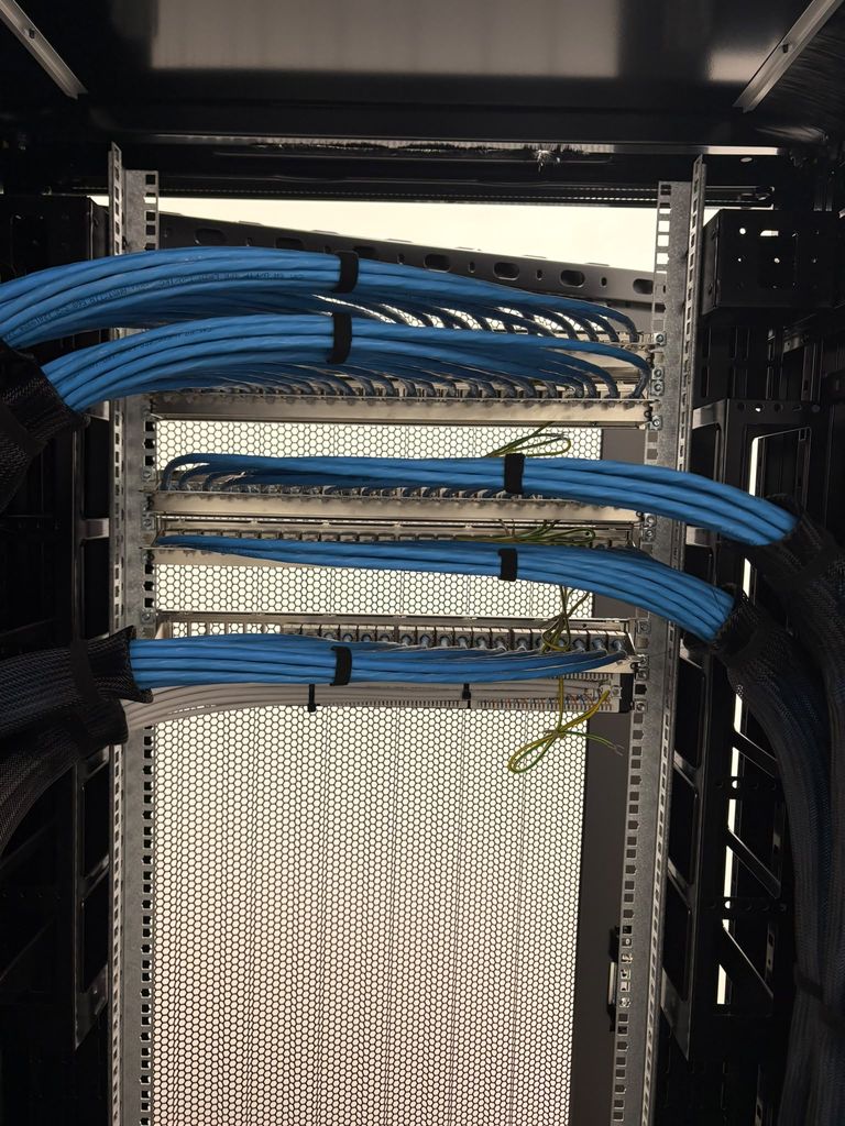 Rear of the patch panels with blue Cat6 looms dressed in and earth bonding tails fitted