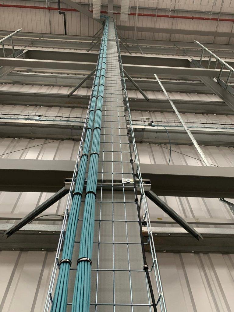Wire basket riser carrying dressed data looms to high level in a warehouse